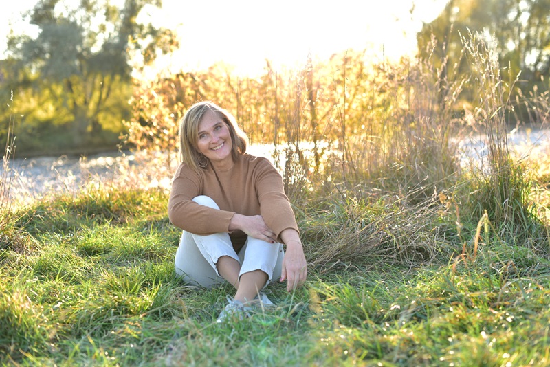 Martina Francesconi sitzend im gruenen an der mur bei sonnenschein